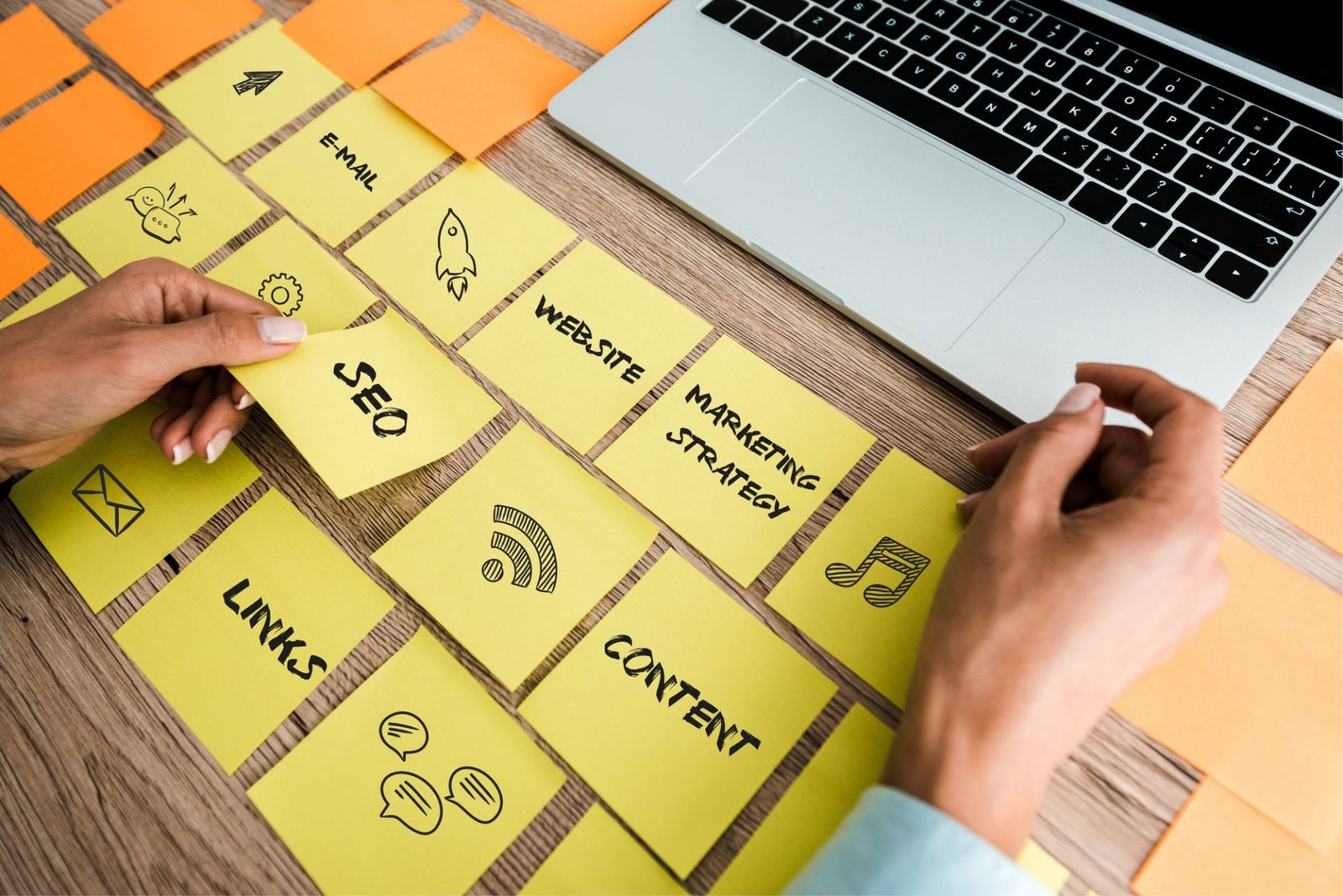 cropped view of woman touching sticky note with seo lettering near laptop on desk e1645158486816
