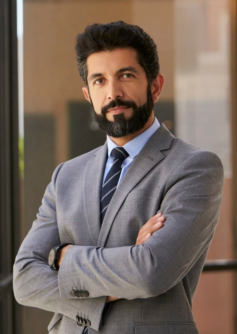 hispanic businessman with arms crossed looking to camera e1645410410706