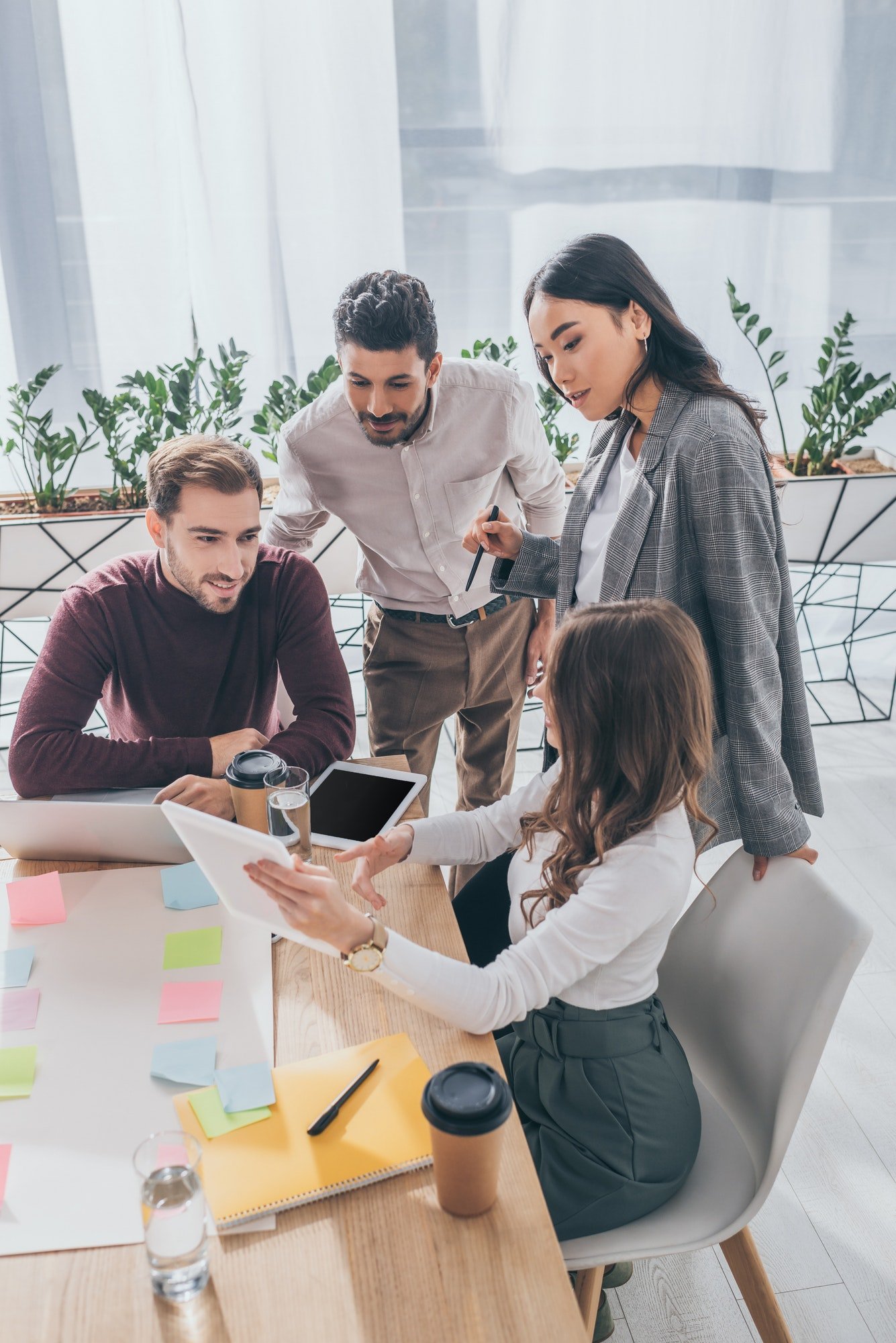 multicultural coworkers looking at digital tablet in office