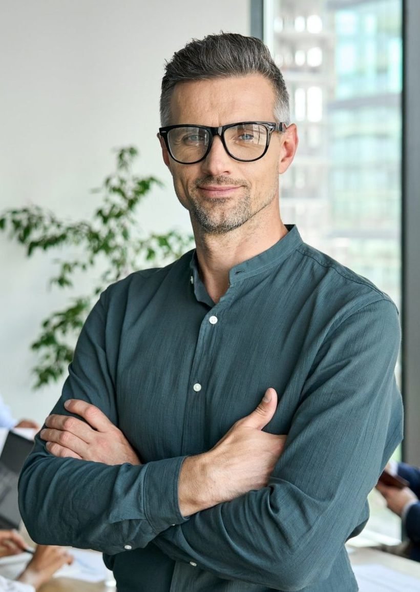 smiling confident mature businessman leader looking at camera in office e1645410800858